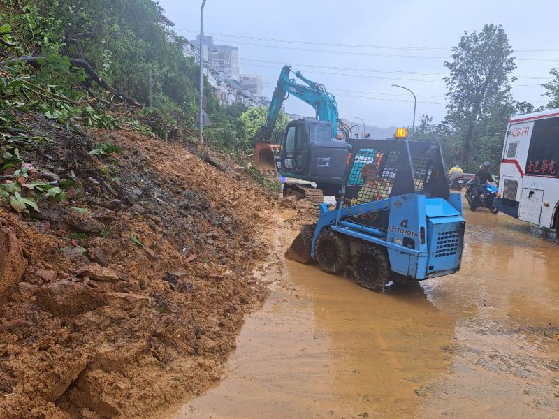 《圖說》新北市連日豪大雨，汐止區伯爵山莊2期擋土牆坍塌，造成康寧街與福德一路口出現土石滑落，養工處及汐止區公所全力搶修。〈工務局提供〉