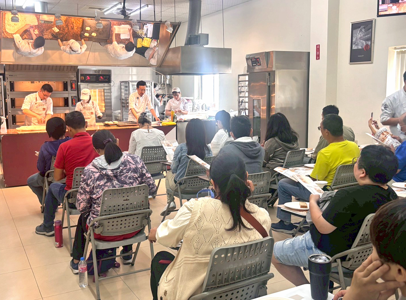 由聯華製粉烘焙顧問楊智偉老師（前方中間站立者）示範全粒粉應用，實作說明吸水、麵團與發酵等關鍵。圖/聯華製粉提供